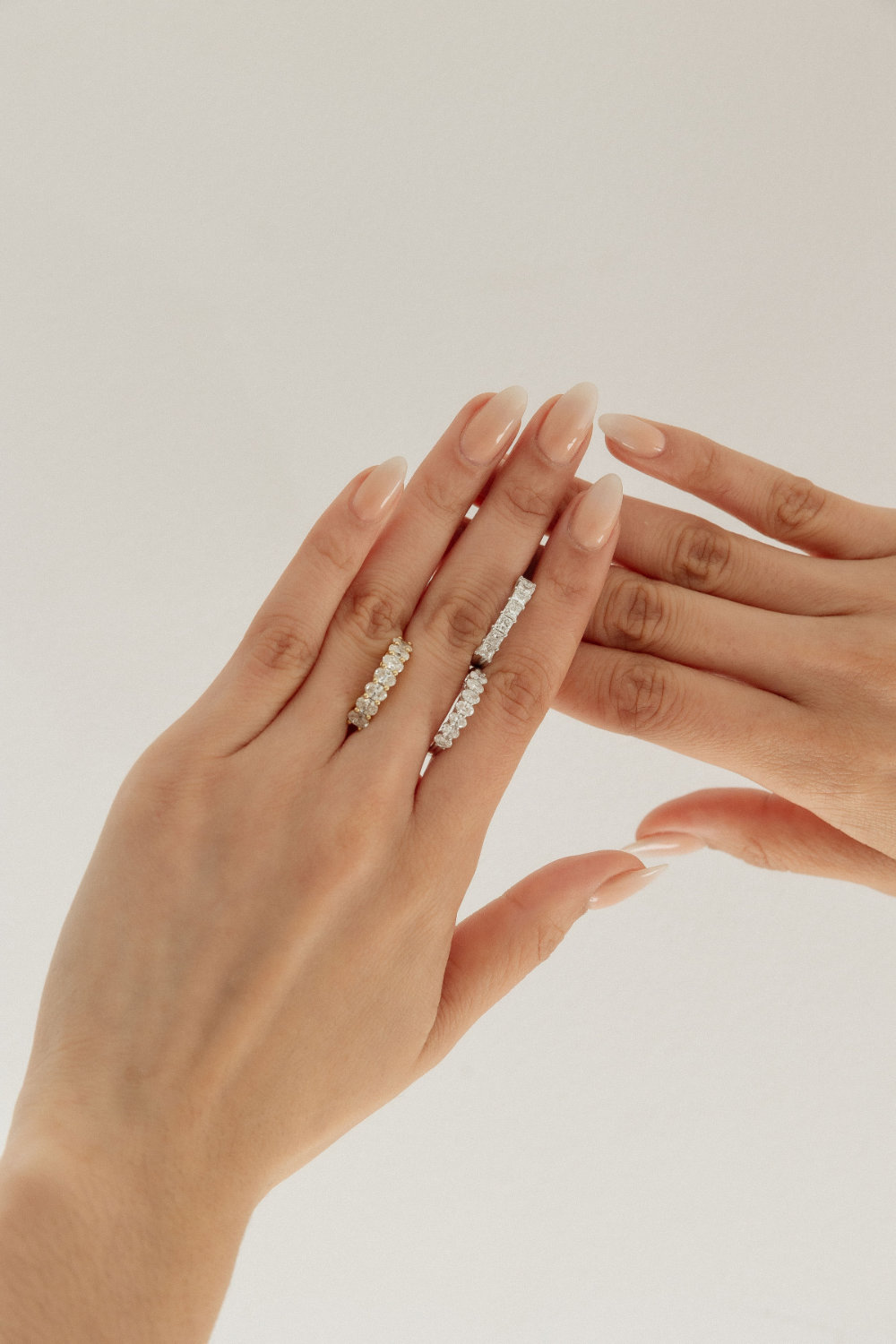 A hand wearing stacked diamond rings